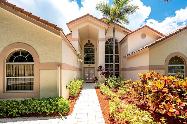 1414 SW Osprey Cv, Port Saint Lucie, FL 34986 - property entrance with french doors, stucco siding, and a tile roof