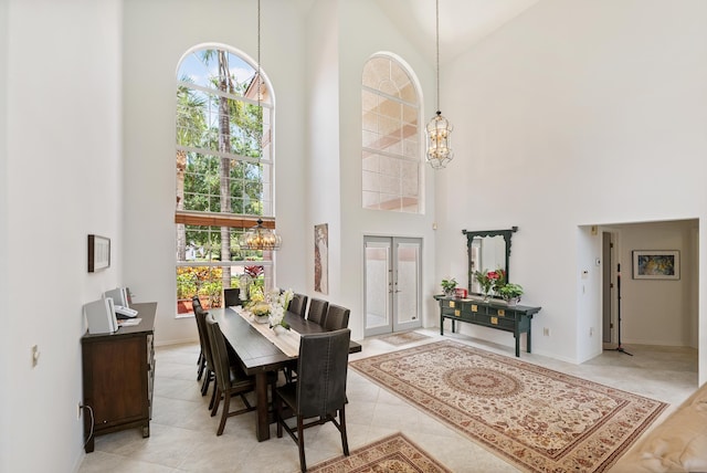 1414 SW Osprey Cv, Port Saint Lucie, FL 34986 - dining space featuring a towering ceiling, a chandelier, baseboards, and light tile patterned floors