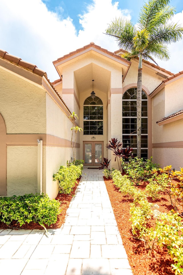 1414 SW Osprey Cv, Port Saint Lucie, FL 34986 - view of exterior entry with french doors, stucco siding, and a tiled roof