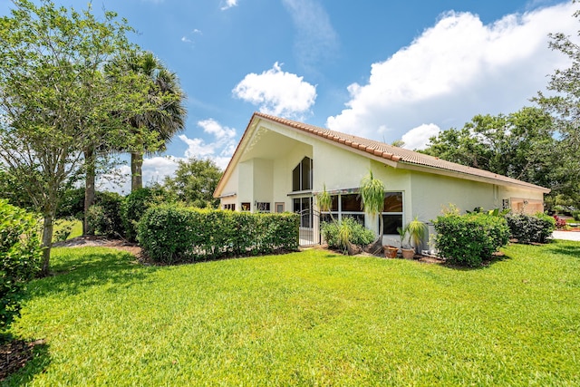 1414 SW Osprey Cv, Port Saint Lucie, FL 34986 - back of property featuring a yard, stucco siding, and a tiled roof