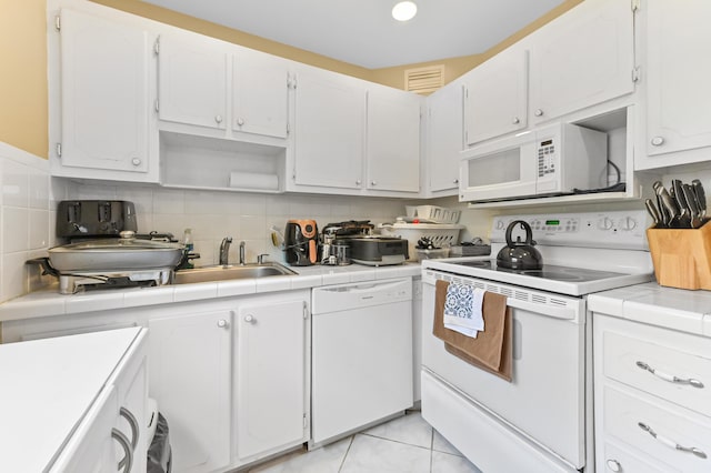 160 Tuscany C, Delray Beach, FL 33446 - kitchen featuring white appliances, tile countertops, white cabinets, and tasteful backsplash