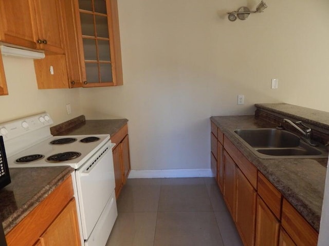 3721 37th Way, West Palm Beach, FL 33407 - kitchen with electric stove, a sink, brown cabinets, glass insert cabinets, and baseboards