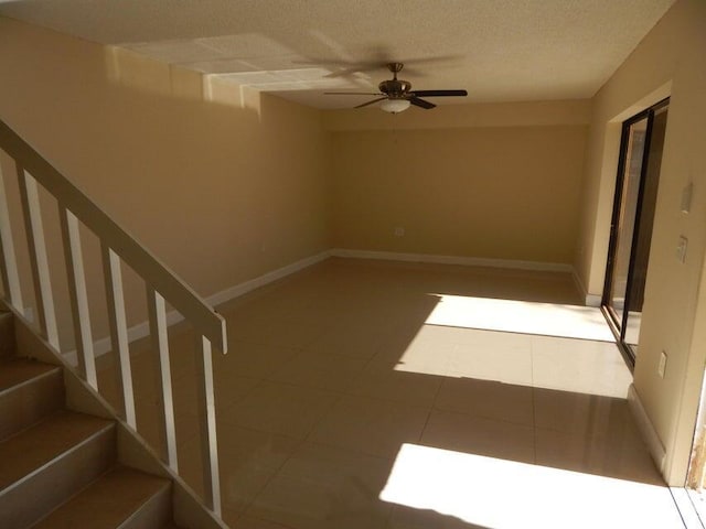 3721 37th Way, West Palm Beach, FL 33407 - tiled spare room with stairs, ceiling fan, baseboards, and a textured ceiling