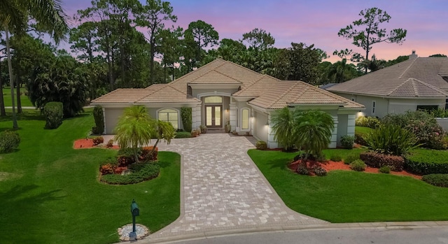 8060 Kiawah Trce, Port Saint Lucie, FL 34986 - mediterranean / spanish home featuring decorative driveway, a garage, a tile roof, a yard, and stucco siding