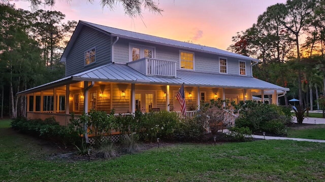 16095 121st Ter N, Jupiter, FL 33478 - view of front facade with covered porch, a yard, metal roof, french doors, and a standing seam roof