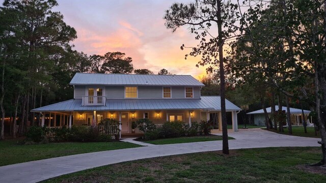 16095 121st Ter N, Jupiter, FL 33478 - farmhouse-style home with covered porch, driveway, metal roof, and a front lawn