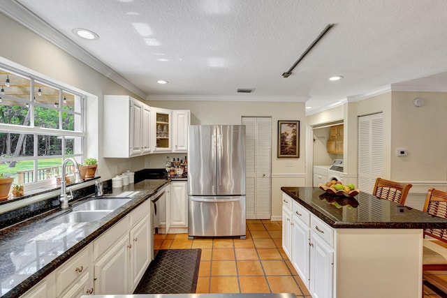 16095 121st Ter N, Jupiter, FL 33478 - kitchen featuring stainless steel appliances, a sink, washer and dryer, glass insert cabinets, and white cabinets