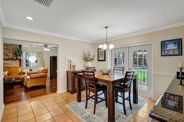 16095 121st Ter N, Jupiter, FL 33478 - dining space with light tile patterned floors, crown molding, a chandelier, french doors, and a ceiling fan