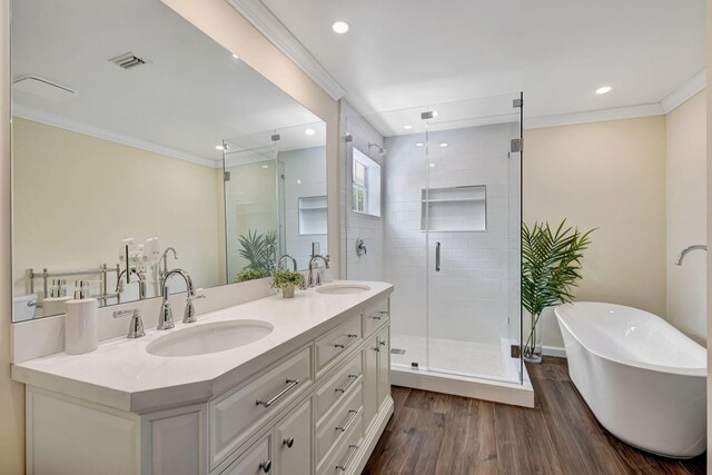 16095 121st Ter N, Jupiter, FL 33478 - full bathroom featuring double vanity, a soaking tub, ornamental molding, a stall shower, and wood finished floors