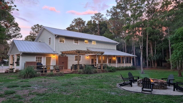 16095 121st Ter N, Jupiter, FL 33478 - rear view of house with a fire pit, a pergola, a wooden deck, a yard, and metal roof