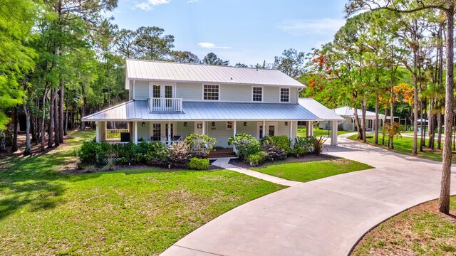 16095 121st Ter N, Jupiter, FL 33478 - country-style home with metal roof, french doors, driveway, a porch, and a front yard
