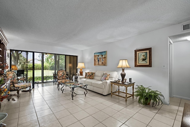 5153 Oak Hill Ln Unit 512, Delray Beach, FL 33484 - living room featuring a textured ceiling and light tile patterned flooring