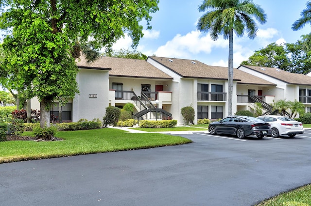 5153 Oak Hill Ln Unit 512, Delray Beach, FL 33484 - view of property with stairway and uncovered parking