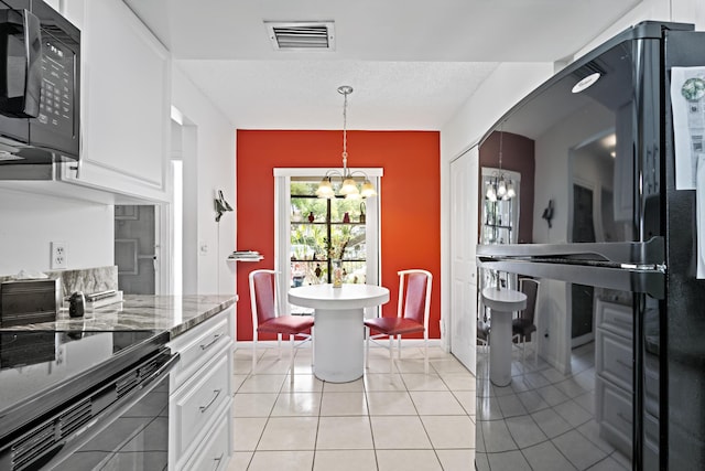 5153 Oak Hill Ln Unit 512, Delray Beach, FL 33484 - kitchen with black appliances, a chandelier, white cabinetry, hanging light fixtures, and light stone counters