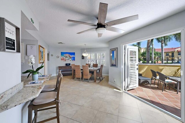 20 Uno Lago Dr, Juno Beach, FL 33408 - dining area with a textured ceiling, a ceiling fan, light tile patterned flooring, and baseboards