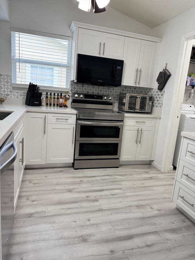1518 Royal Forest Ct, Palm Springs, FL 33406 - kitchen featuring appliances with stainless steel finishes, tasteful backsplash, white cabinets, light wood-style floors, and vaulted ceiling