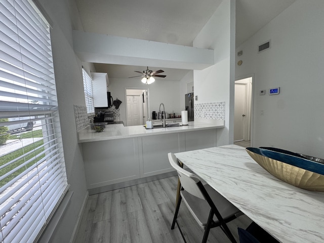 1518 Royal Forest Ct, Palm Springs, FL 33406 - kitchen with stainless steel fridge with ice dispenser, light wood finished floors, tasteful backsplash, a ceiling fan, and a sink
