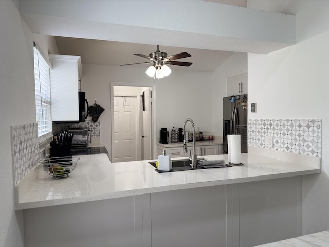 1518 Royal Forest Ct, Palm Springs, FL 33406 - kitchen featuring refrigerator with ice dispenser, a peninsula, tasteful backsplash, a ceiling fan, and black microwave