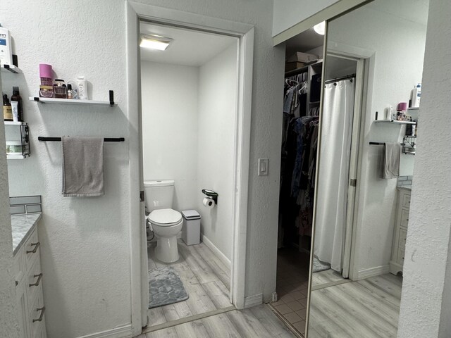 1518 Royal Forest Ct, Palm Springs, FL 33406 - full bathroom with wood finished floors, toilet, vanity, and a spacious closet