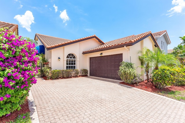23193 Via Stel, Boca Raton, FL 33433 - mediterranean / spanish home with an attached garage, stucco siding, a tile roof, and decorative driveway