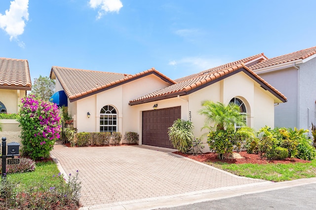 23193 Via Stel, Boca Raton, FL 33433 - mediterranean / spanish-style home featuring a garage, driveway, a tile roof, and stucco siding