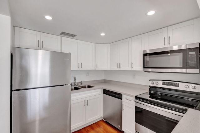 2936 Lake Shore Dr Unit 108, Riviera Beach, FL 33404 - kitchen with stainless steel appliances, light countertops, recessed lighting, and white cabinets