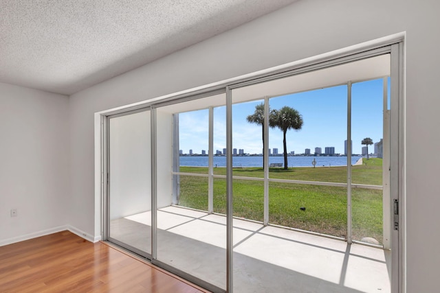 2936 Lake Shore Dr Unit 108, Riviera Beach, FL 33404 - unfurnished room featuring a water view, wood finished floors, healthy amount of natural light, and a textured ceiling