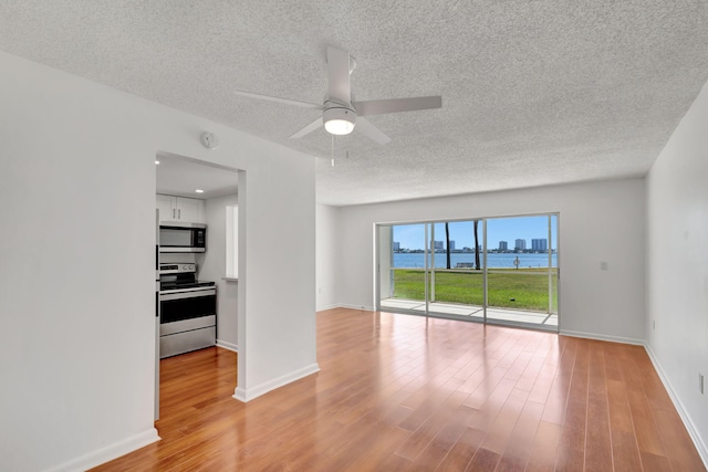2936 Lake Shore Dr Unit 108, Riviera Beach, FL 33404 - unfurnished room with a textured ceiling, light wood-type flooring, a ceiling fan, a water view, and a smoke detector