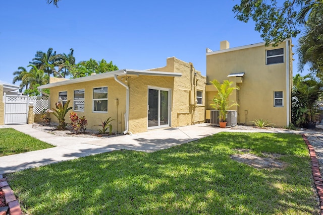 811 Hunter St, West Palm Beach, FL 33405 - back of house featuring stucco siding, a gate, a patio area, and central AC unit