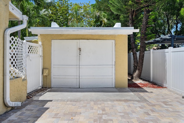 811 Hunter St, West Palm Beach, FL 33405 - garage featuring a storage shed, a gate, and driveway