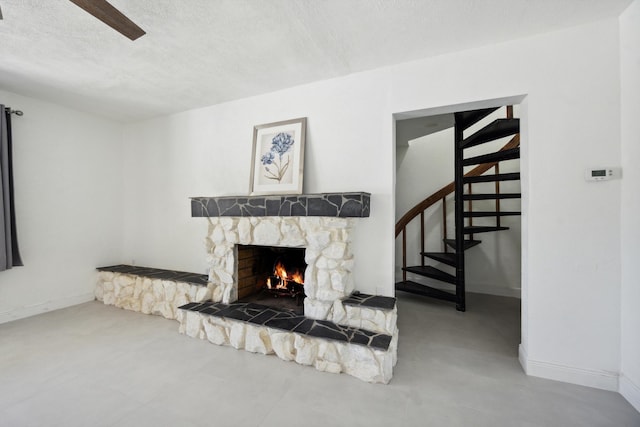 811 Hunter St, West Palm Beach, FL 33405 - living room with a stone fireplace, stairway, a ceiling fan, baseboards, and a textured ceiling
