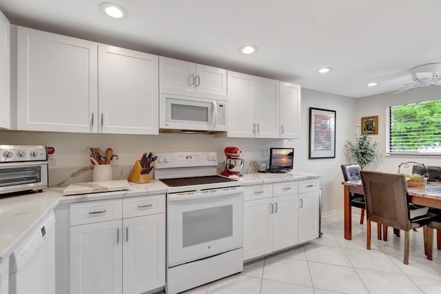 15075 Witney Rd Unit 212, Delray Beach, FL 33484 - kitchen featuring white appliances, white cabinets, light tile patterned floors, light stone countertops, and recessed lighting