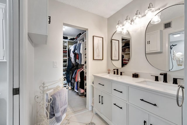 15075 Witney Rd Unit 212, Delray Beach, FL 33484 - full bathroom featuring double vanity, a textured ceiling, tile patterned flooring, and a spacious closet