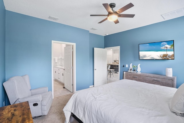 2431 Crowned Eagle Cir SW, Vero Beach, FL 32962 - bedroom with light carpet, ceiling fan, ensuite bath, and a textured ceiling