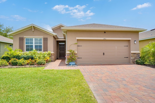 2431 Crowned Eagle Cir SW, Vero Beach, FL 32962 - ranch-style home featuring stucco siding, a front yard, stone siding, decorative driveway, and a garage