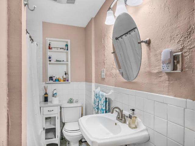 505 Palmetto St, West Palm Beach, FL 33405 - full bathroom with toilet, a wainscoted wall, a sink, tile walls, and curtained shower
