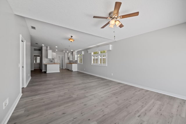 10834 SW Dardanelle Dr, Port Saint Lucie, FL 34987 - unfurnished living room with ceiling fan, baseboards, and wood finished floors
