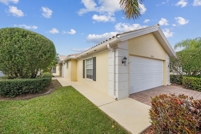 10834 SW Dardanelle Dr, Port Saint Lucie, FL 34987 - view of home's exterior featuring stucco siding, a tiled roof, a lawn, driveway, and a garage