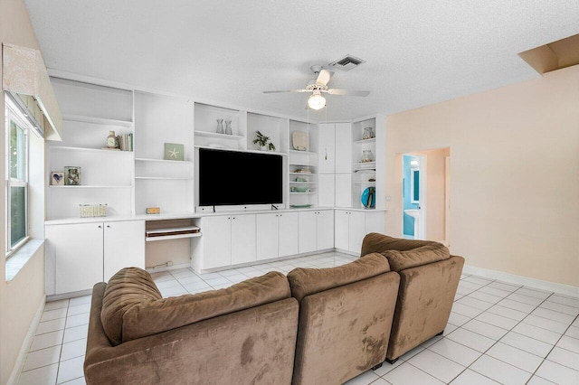 6321 Lansdowne Cir, Boynton Beach, FL 33472 - living room with ceiling fan, light tile patterned flooring, built in shelves, baseboards, and a textured ceiling