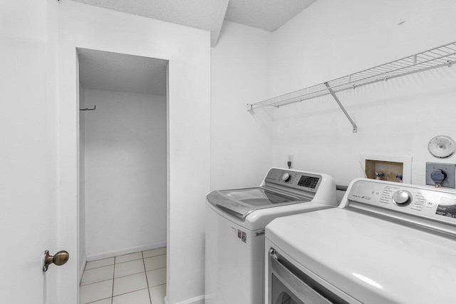 6321 Lansdowne Cir, Boynton Beach, FL 33472 - laundry area with washing machine and clothes dryer, light tile patterned flooring, a textured ceiling, and baseboards
