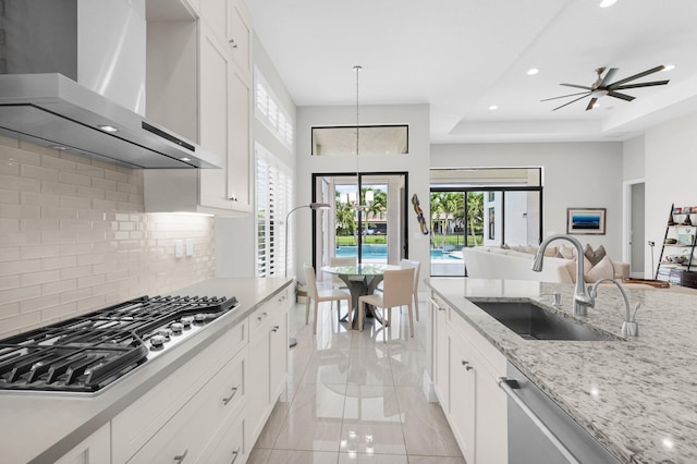 9350 Eden Roc Ct, Delray Beach, FL 33446 - kitchen featuring wall chimney range hood, appliances with stainless steel finishes, a sink, open floor plan, and tasteful backsplash