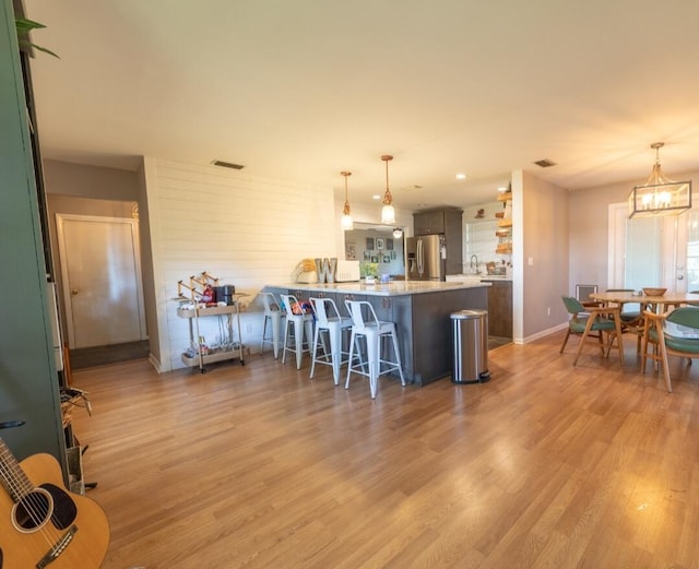 1793 SW 22nd Ter, Okeechobee, FL 34974 - kitchen featuring stainless steel fridge, a peninsula, a kitchen breakfast bar, light countertops, and light wood-style floors