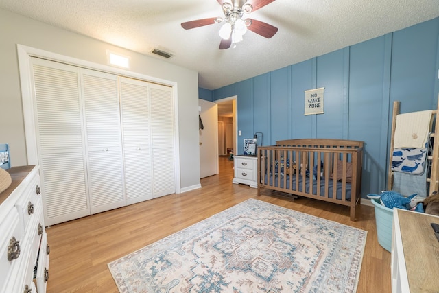 1793 SW 22nd Ter, Okeechobee, FL 34974 - bedroom featuring a decorative wall, a closet, wood finished floors, ceiling fan, and a textured ceiling