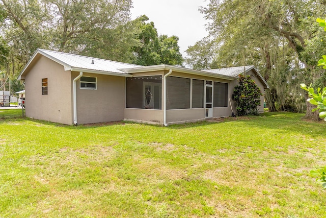 1793 SW 22nd Ter, Okeechobee, FL 34974 - rear view of house with a sunroom, a yard, metal roof, and stucco siding