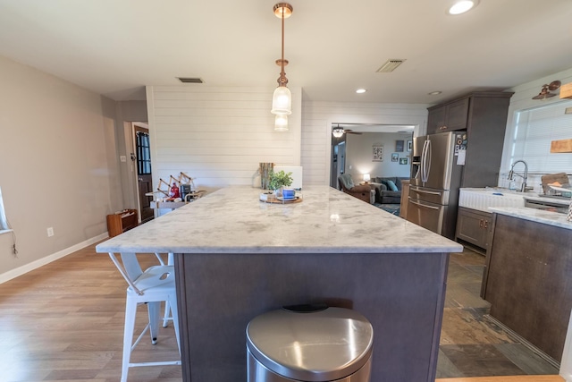 1793 SW 22nd Ter, Okeechobee, FL 34974 - kitchen with stainless steel fridge, a kitchen bar, dark wood finished floors, recessed lighting, and hanging light fixtures