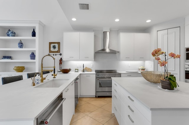 6636 Dana Point Cv, Delray Beach, FL 33446 - kitchen featuring appliances with stainless steel finishes, wall chimney range hood, a sink, light countertops, and white cabinetry