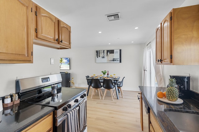 2137 Longwood Rd, West Palm Beach, FL 33409 - kitchen featuring stainless steel range with electric stovetop, light wood-style flooring, recessed lighting, dark stone counters, and brown cabinetry