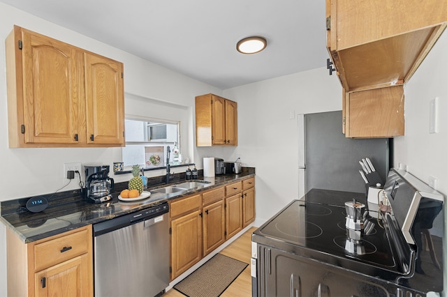 2137 Longwood Rd, West Palm Beach, FL 33409 - kitchen with stainless steel appliances, a sink, light wood finished floors, and dark stone countertops