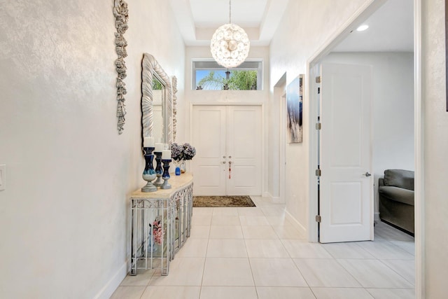 11051 SW Ivory Springs Ln, Port Saint Lucie, FL 34987 - foyer with a chandelier, baseboards, light tile patterned floors, and a tray ceiling