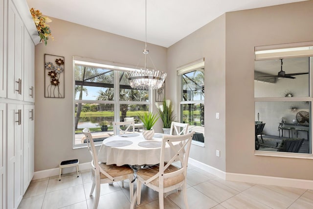 11051 SW Ivory Springs Ln, Port Saint Lucie, FL 34987 - dining space with baseboards, ceiling fan, a chandelier, light tile patterned floors, and a water view